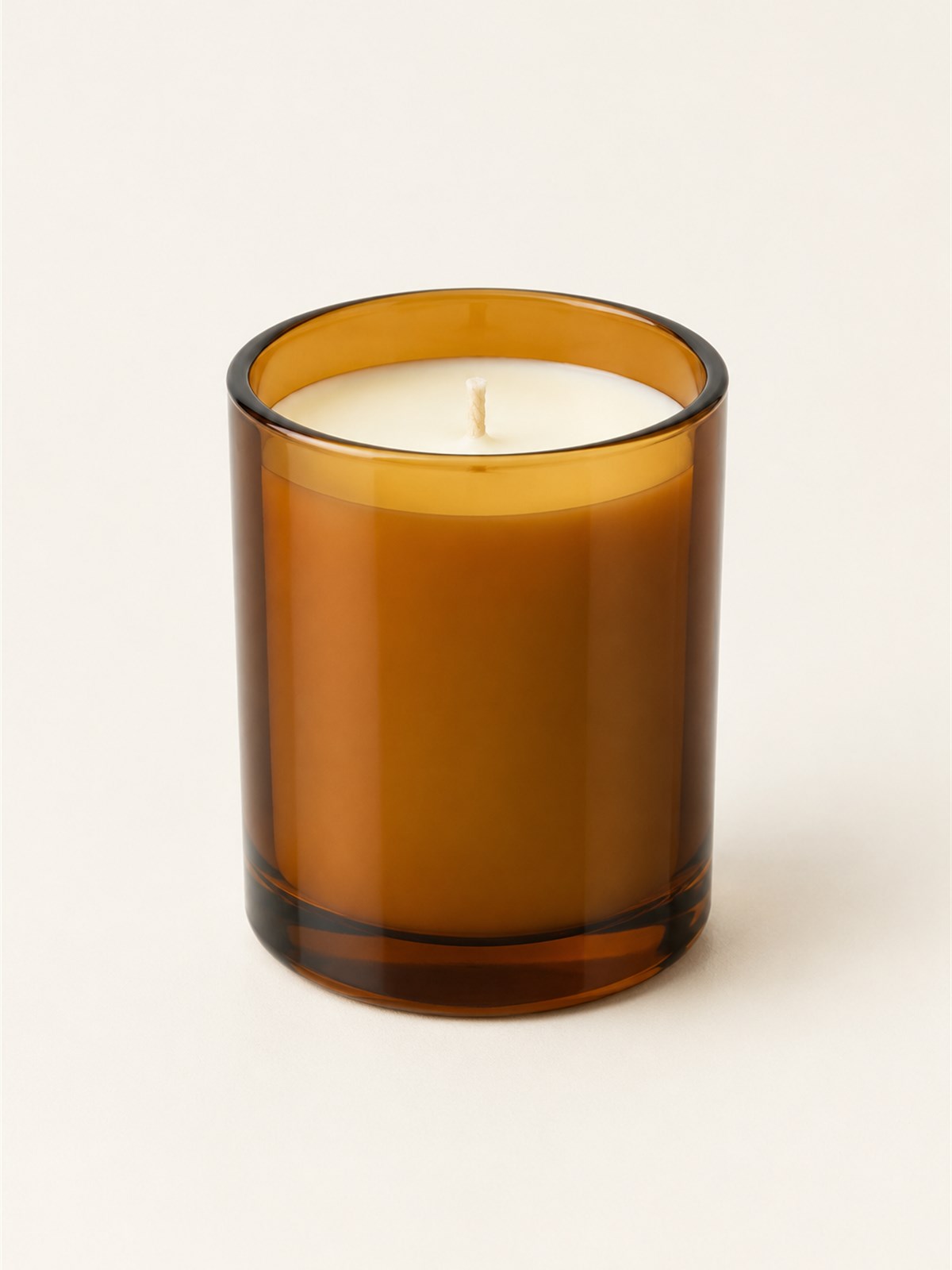 Hearth No. 1 candle in an amber glass vessel on a stone ledge